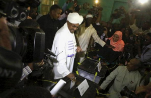 Sudan's President Omar Hassan al-Bashir (C) casts his ballot during electons in the capital Khartoum.