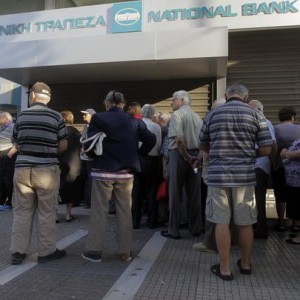 People wait in line outside a National Bank of Greece